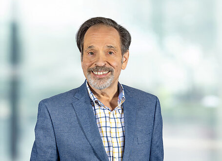Mark Klein on light blue and white bokeh banner